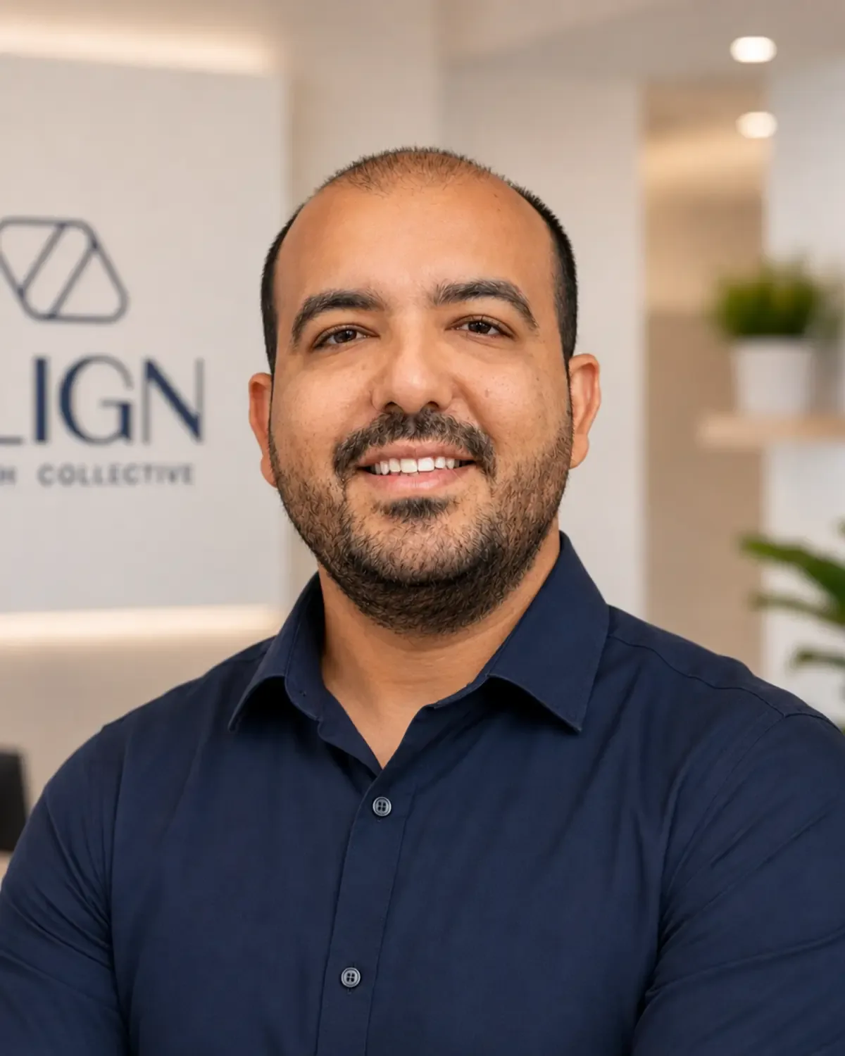 David Wassef, podiatrist, bearded, in a navy shirt at the clinic reception, in front of the Align Health Collective sign.